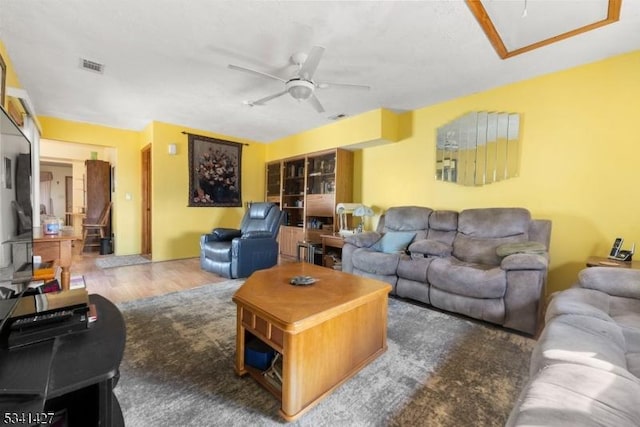 living room featuring visible vents, a ceiling fan, and wood finished floors