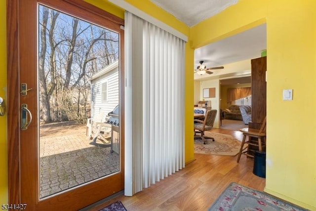 doorway to outside featuring ceiling fan and wood finished floors