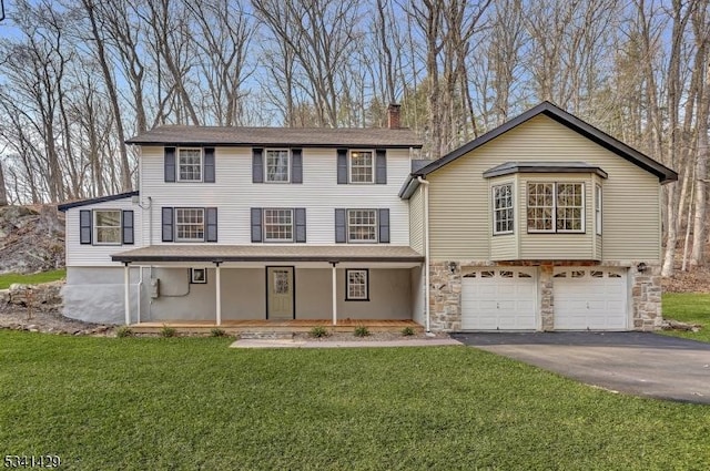 view of front of house with aphalt driveway, a porch, a front yard, a garage, and stone siding