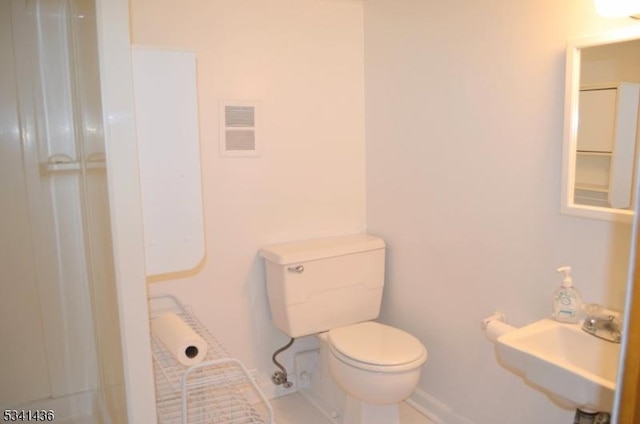 bathroom featuring toilet, visible vents, a shower, and a sink