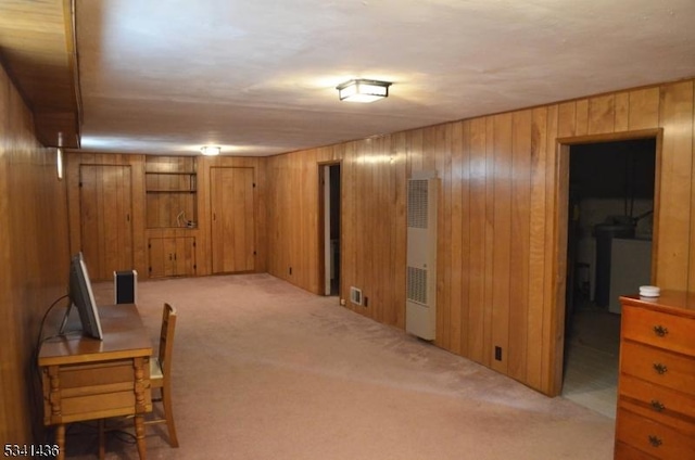 below grade area with carpet floors, wood walls, and visible vents