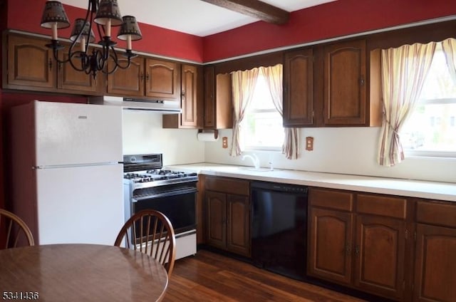 kitchen featuring black dishwasher, freestanding refrigerator, under cabinet range hood, a sink, and gas stove