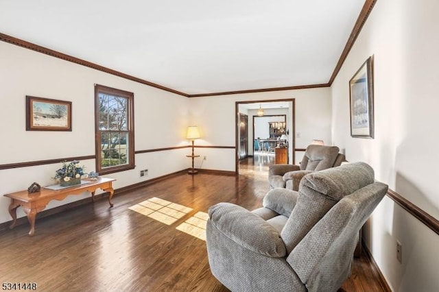 living area featuring ornamental molding, baseboards, and wood finished floors