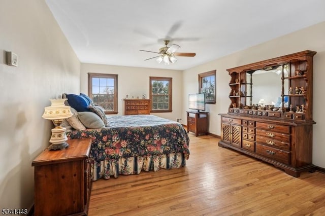 bedroom with ceiling fan, baseboards, and wood finished floors