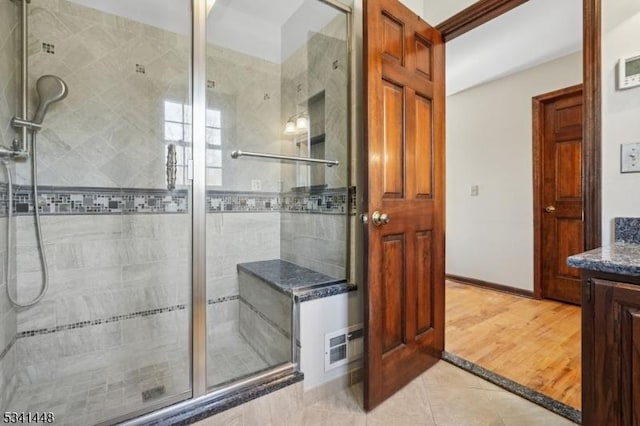 bathroom with baseboards, a stall shower, vanity, and tile patterned floors