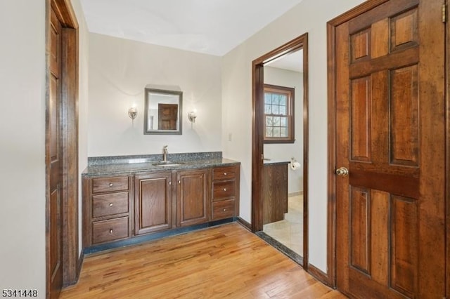 bathroom with baseboards, wood finished floors, and vanity