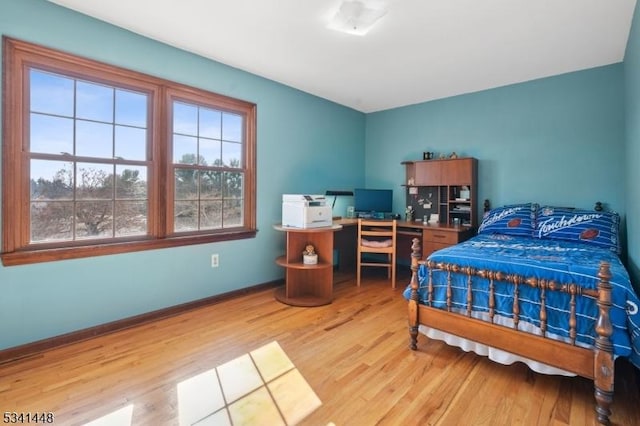 bedroom featuring baseboards and light wood finished floors