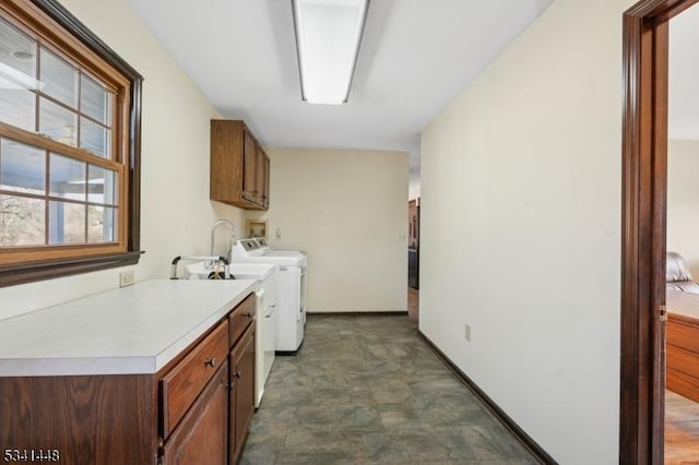 laundry room with washing machine and dryer, cabinet space, and baseboards