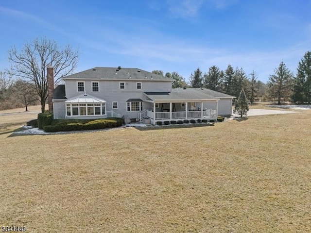 back of house featuring a yard and a chimney