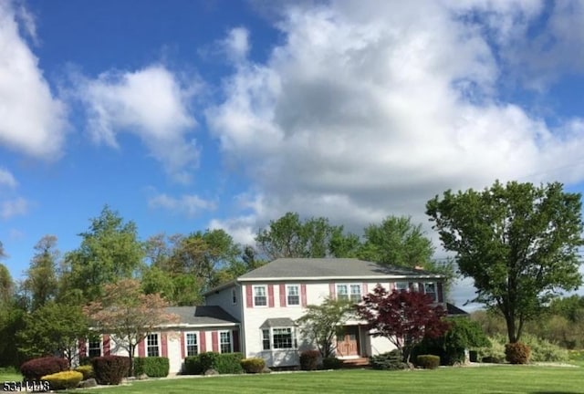 colonial inspired home featuring a front lawn