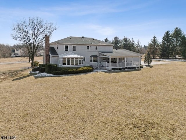 back of house with a yard and a chimney