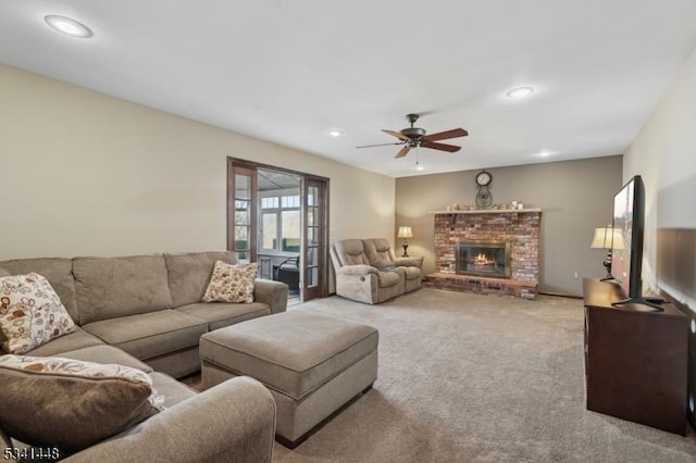 carpeted living area with ceiling fan, a fireplace, and recessed lighting