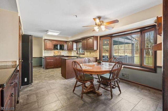 dining area with ceiling fan and baseboards