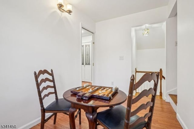 dining space with baseboards and light wood finished floors