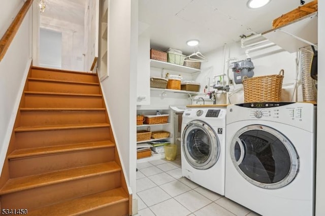 clothes washing area featuring separate washer and dryer, light tile patterned flooring, and laundry area