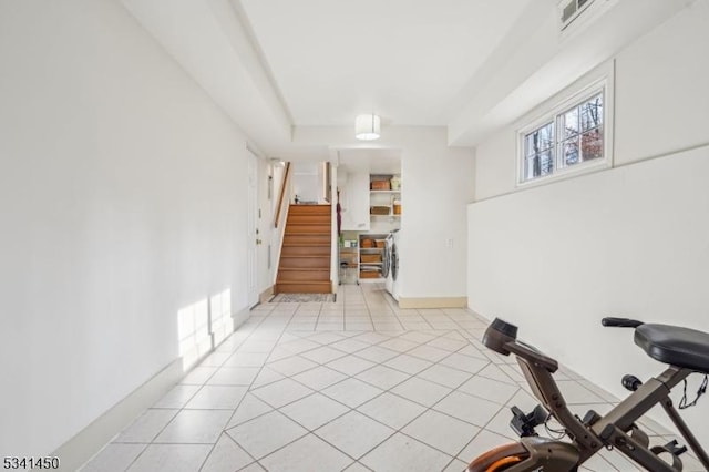 exercise area with washer / clothes dryer, light tile patterned floors, baseboards, and visible vents