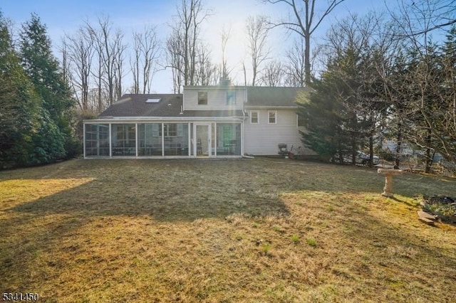 back of house featuring a yard and a sunroom