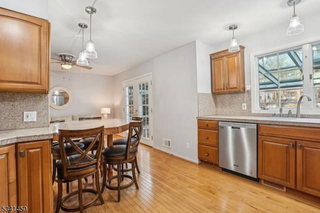 kitchen featuring light wood-style flooring, plenty of natural light, ceiling fan, a sink, and stainless steel dishwasher