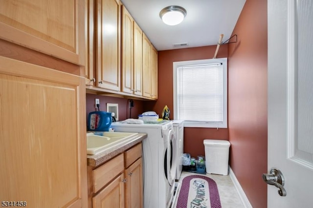 laundry room with a sink, visible vents, baseboards, cabinet space, and washer and clothes dryer