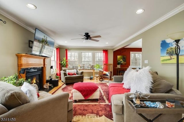 living room with recessed lighting, ornamental molding, ceiling fan, and a glass covered fireplace