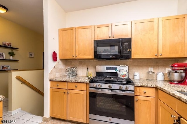 kitchen with stainless steel gas range oven, black microwave, light tile patterned floors, decorative backsplash, and light stone countertops