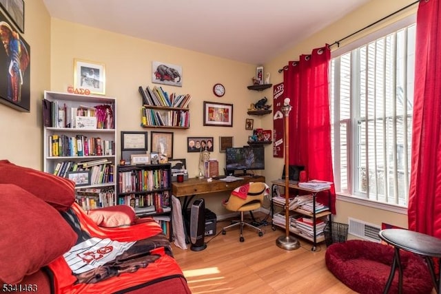 office with visible vents, a healthy amount of sunlight, and wood finished floors