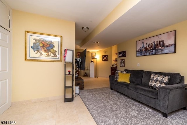 living room featuring light tile patterned floors, visible vents, and baseboards