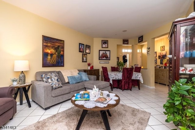 living area with light tile patterned floors and baseboards