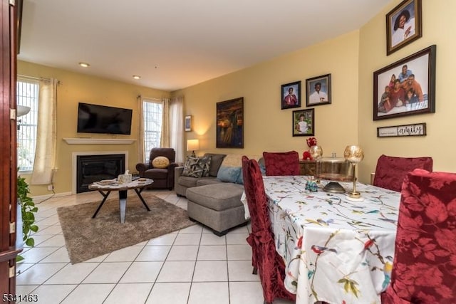 interior space featuring a glass covered fireplace and light tile patterned floors