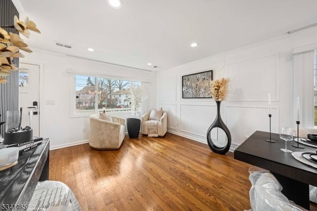 interior space with recessed lighting, visible vents, a decorative wall, and wood finished floors