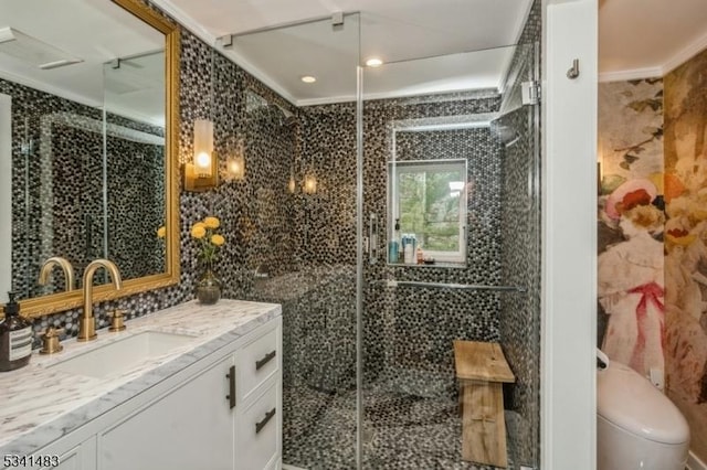 bathroom with toilet, a stall shower, tile walls, and vanity