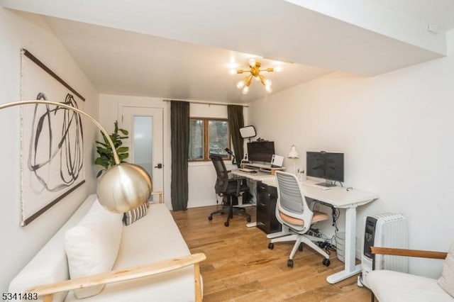 home office featuring a notable chandelier and wood finished floors