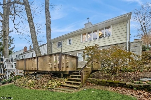 back of house with a chimney and a deck