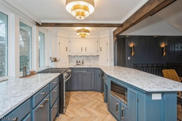 kitchen featuring crown molding, blue cabinetry, backsplash, gas stove, and a peninsula