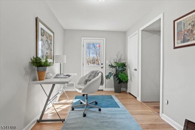 office featuring baseboards, visible vents, and light wood-style floors