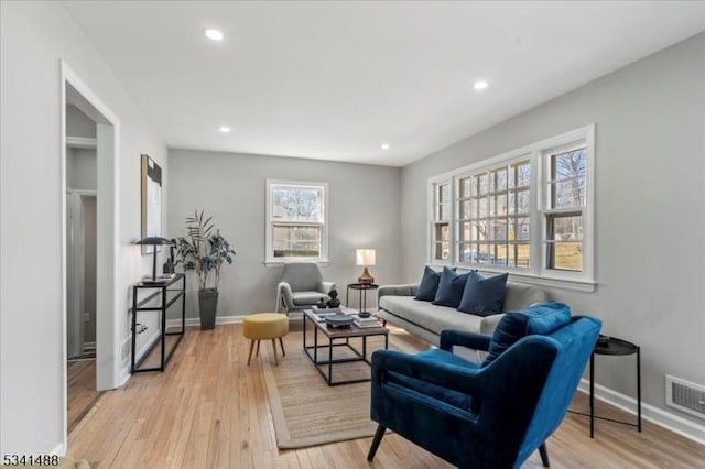 living area featuring recessed lighting, visible vents, light wood-style flooring, and baseboards