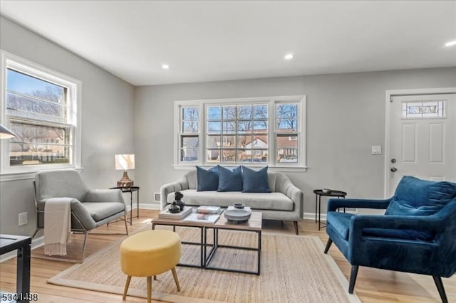 living room featuring baseboards, light wood-type flooring, and recessed lighting