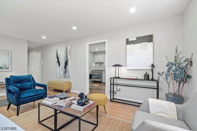 living area featuring light wood-style floors, baseboards, and recessed lighting