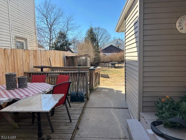 view of patio / terrace featuring outdoor dining area, fence, and a wooden deck