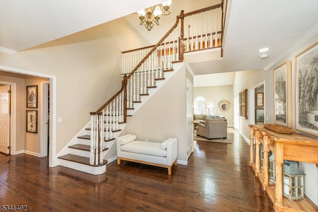 staircase featuring baseboards, wood finished floors, vaulted ceiling, crown molding, and a notable chandelier