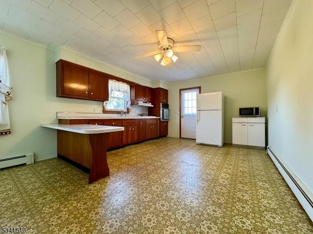 kitchen with a baseboard heating unit, stainless steel appliances, a peninsula, and tile patterned floors