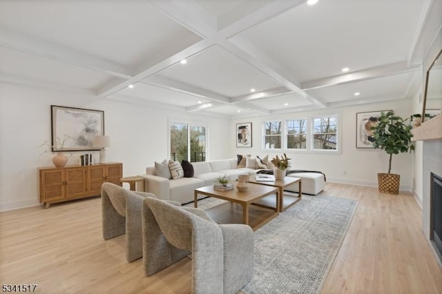 living area featuring beam ceiling, light wood-style flooring, a fireplace, and coffered ceiling