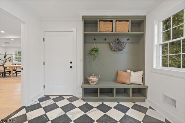 mudroom with crown molding, baseboards, visible vents, and tile patterned floors