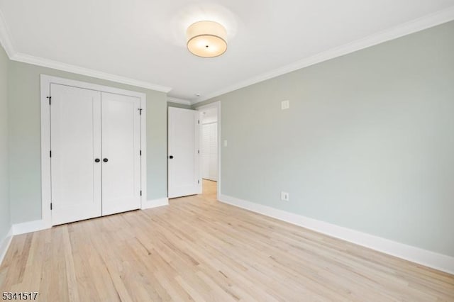 unfurnished bedroom with light wood finished floors, a closet, baseboards, and ornamental molding