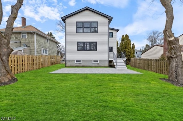 rear view of house with a yard, a patio area, and a fenced backyard