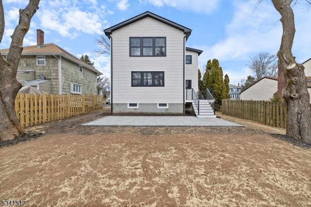 rear view of property featuring a patio and fence