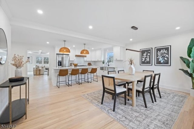 dining space featuring recessed lighting, baseboards, ornamental molding, and light wood finished floors