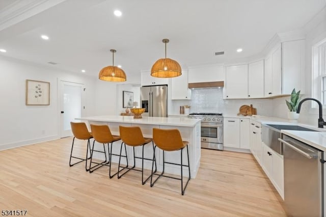 kitchen with light wood-style flooring, a center island, recessed lighting, and stainless steel appliances