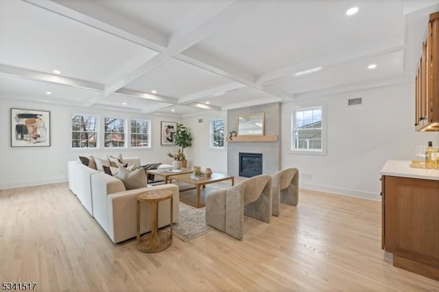 living room with beamed ceiling, baseboards, light wood-style floors, and coffered ceiling