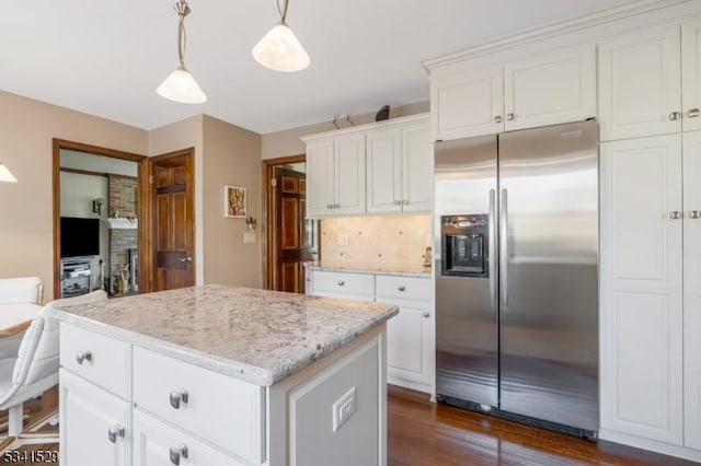 kitchen featuring light stone counters, dark wood-style flooring, white cabinetry, a kitchen island, and stainless steel fridge with ice dispenser